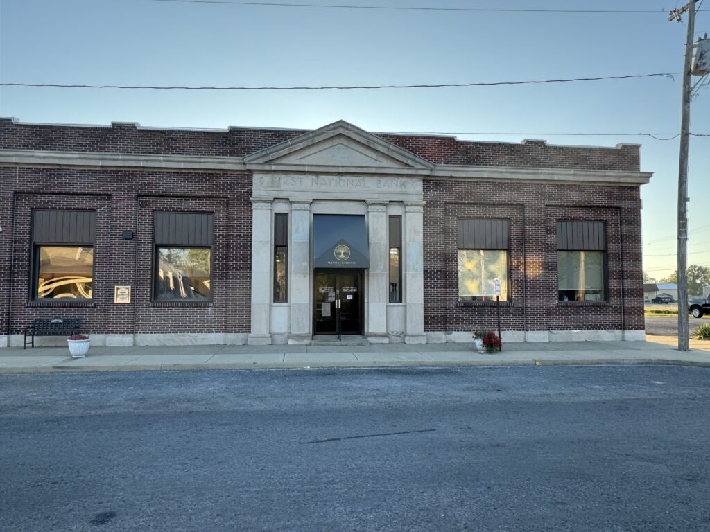 Photograph of main bank building, front entrance with large columns, located in Sandoval, IL.
